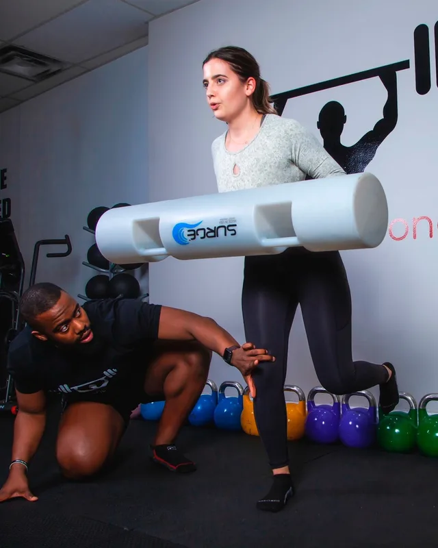 Daniel Smith coaching a member through a weighted lunge