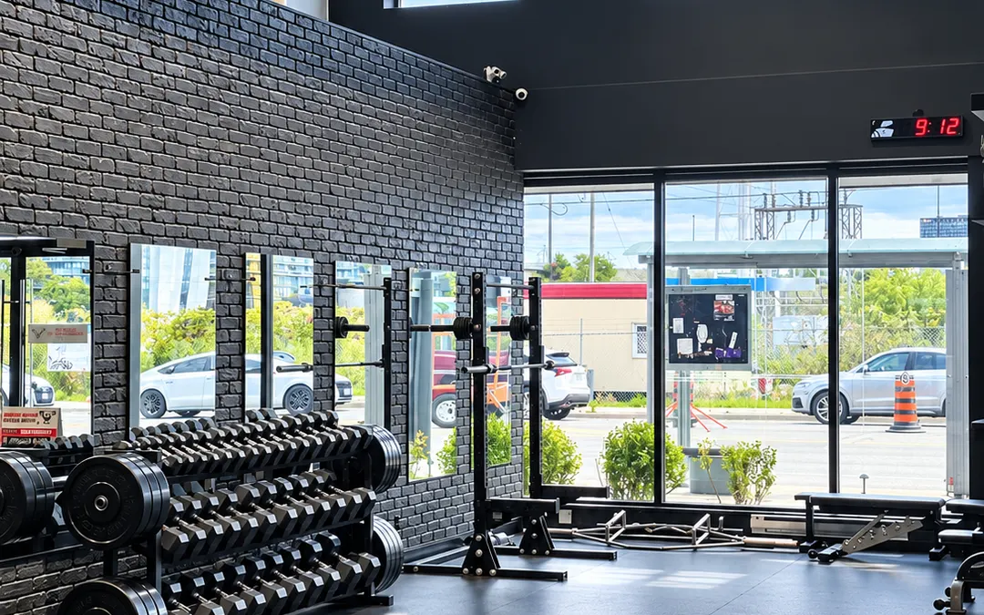 The Etobicoke studio: dumbbell racks, black brick and floor-to-ceiling windows